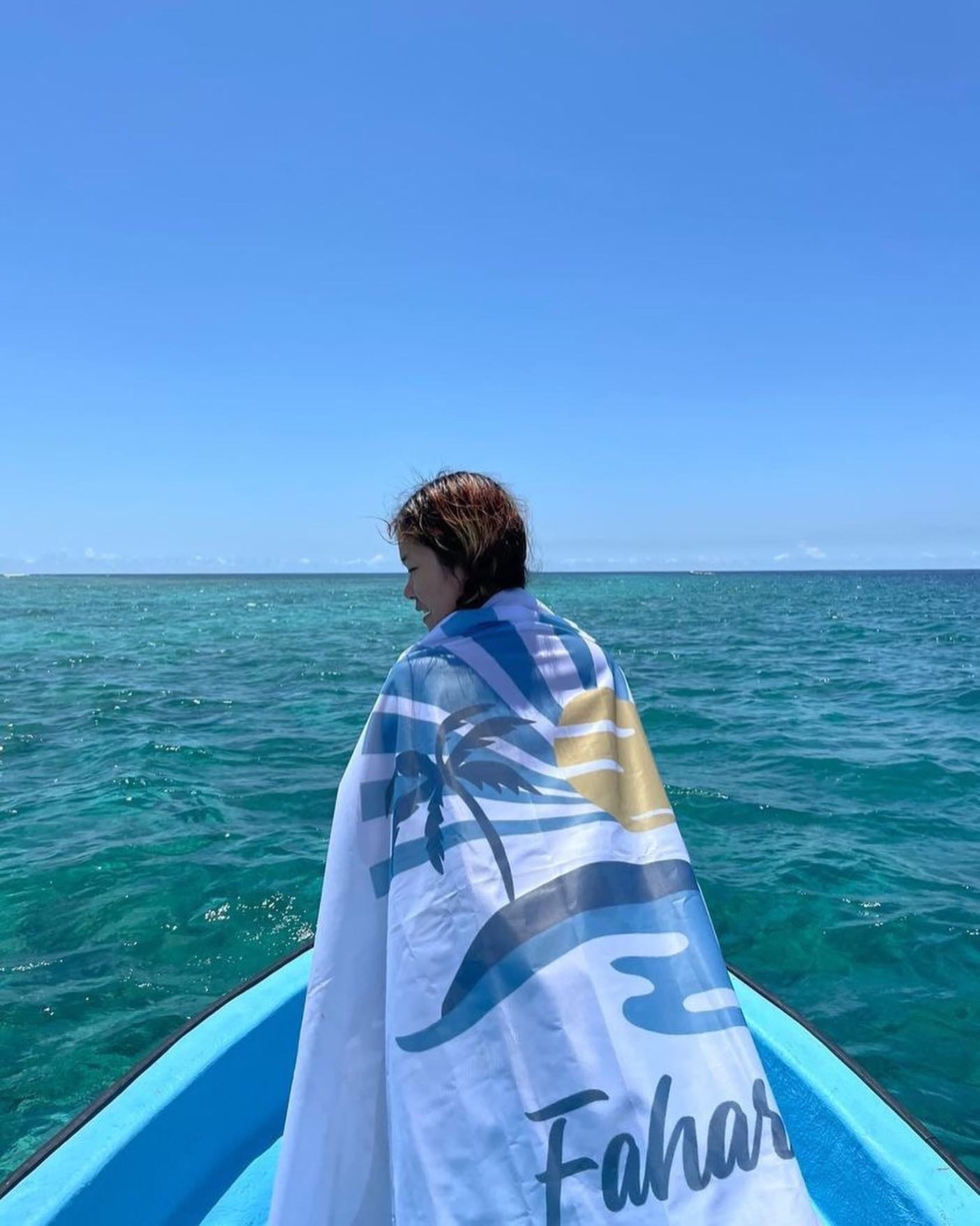 Guest wrapped in the Fahari flag on a boat bow
